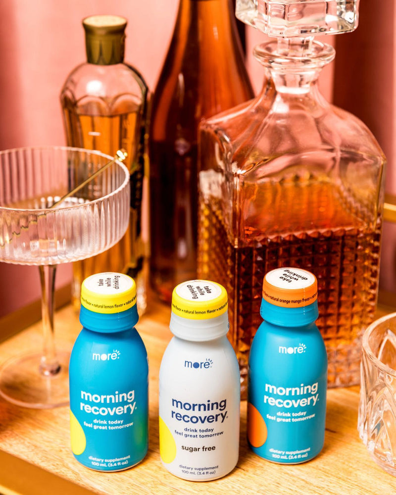 More Labs Morning Recovery bottles displayed beside glassware and spirits for a before-drinking routine.