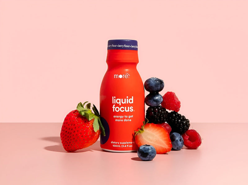 More Labs Liquid Focus nootropic drink in an orange bottle surrounded by fresh berries.
