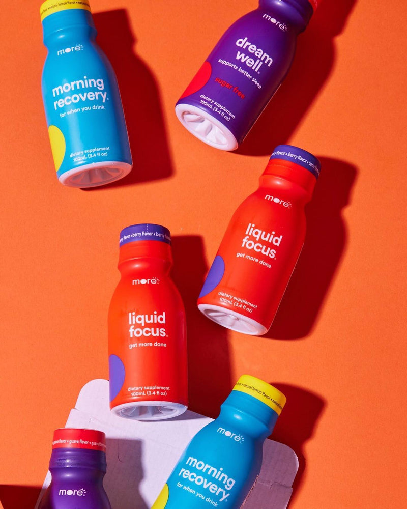 Assorted More Labs bottles of Morning Recovery, Liquid Focus, and Dream Well on an orange background.