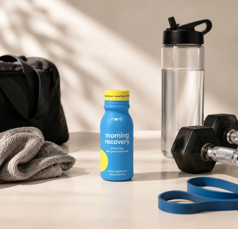 More Labs Morning Recovery dietary supplement bottle beside workout gear and a water bottle.