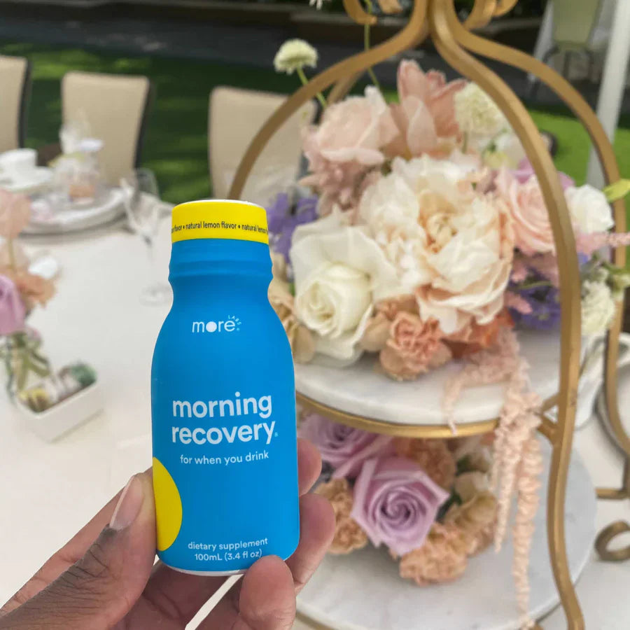 Morning Recovery dietary supplement by More Labs on a wedding table beside pastel floral décor.