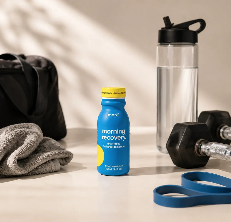 More Labs Morning Recovery dietary supplement bottle beside workout gear and a water bottle.