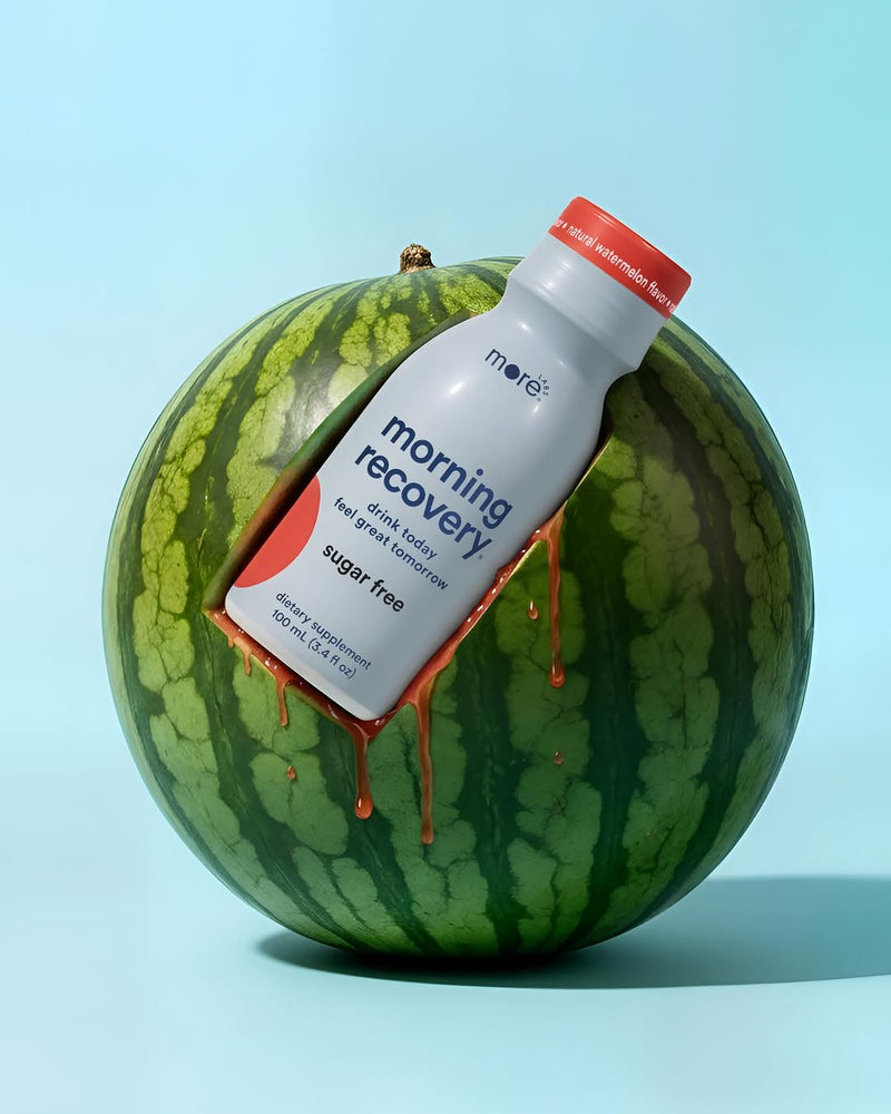 More Labs Morning Recovery bottle embedded in a watermelon with juice dripping down the sides.