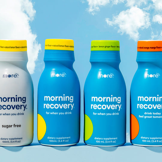More Labs Morning Recovery bottles in assorted flavors against a blue sky background.
